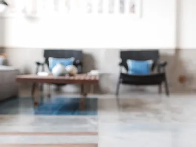 A spacious lounge area with concrete flooring and wooden accents.
