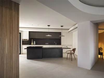 Modern minimalist kitchen featuring a black countertop and concrete floor.