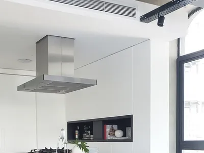 Modern kitchen with concrete and marble countertop, stainless steel appliances, black leather bar stools, and a window with n