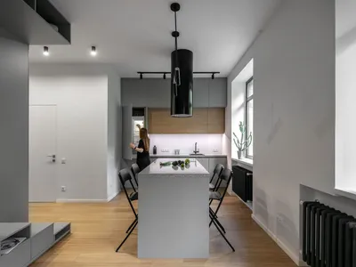 A minimalist kitchen with white marble countertops and stainless steel appliances.
