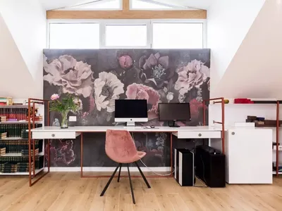 Home office with a modern design featuring a wooden floor and floral wallpaper.