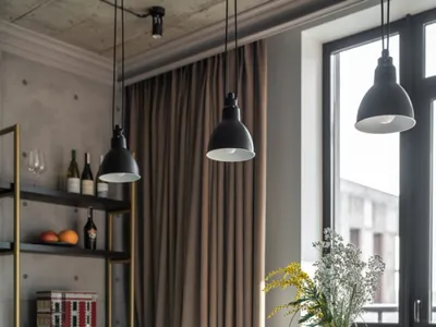 Industrial-style living room with concrete floor, metal furniture, and large windows.