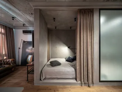 Minimalist bedroom with concrete walls, a bed, and a built-in niche.