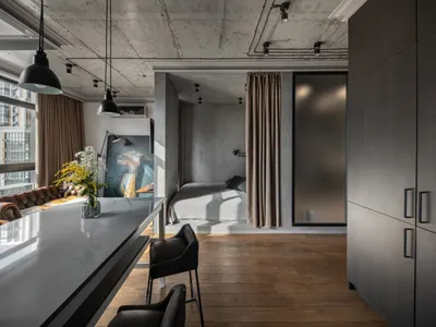 一間擁有混凝土牆面、木質地板與金屬元素的現代工業風臥室。