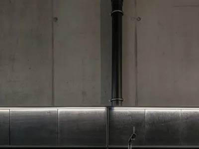 現代簡約廚房，搭配黑色金屬櫥櫃與瓷磚背板。