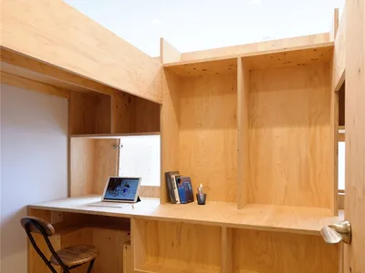 A modern home office with a wooden desk and chair.