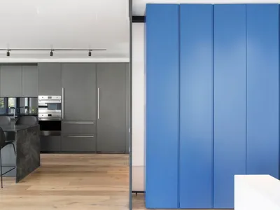 Minimalist kitchen with blue and gray cabinets and walls