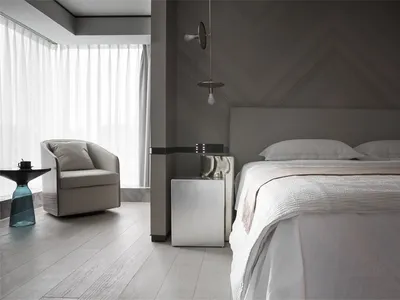 A minimalist bedroom featuring a metal panel wall, white bed, and wooden floor.