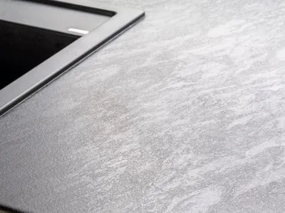 Modern kitchen featuring a stone countertop with a brass handle.