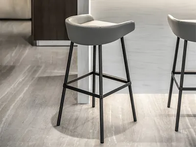 Modern kitchen with marble countertops and dark cabinets, featuring sleek bar stools and a minimalist design.