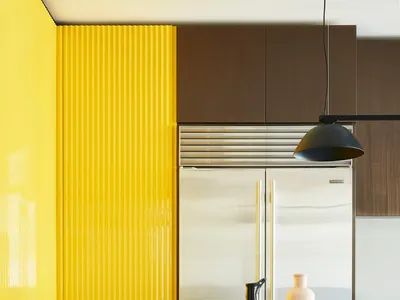 Modern kitchen featuring a yellow metal cabinet, polished wood accents, and ceramic elements.