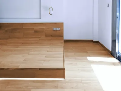 Minimalist bedroom with wooden flooring, emphasizing a modern and clean design.