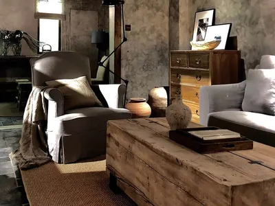 A cozy industrial-style living room featuring rustic wooden furniture and semi-transparent ceiling beams.