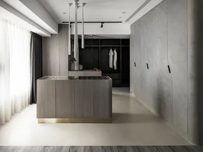 A modern kitchen with minimalist design, featuring concrete and wood materials.