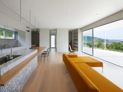 A contemporary residential living room featuring marble countertops, wooden flooring, and glass elements.