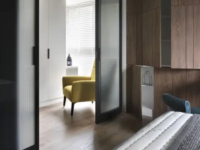 A modern minimalist bedroom with wooden furniture and white walls.