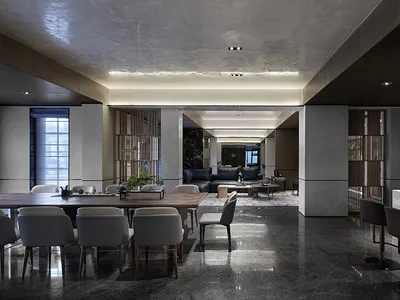 Modern living, dining, and kitchen area with marble countertops, concrete floor, and minimalist design.