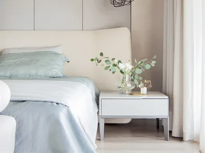 Modern minimalist bedroom featuring fabric, metallic, and glass elements.