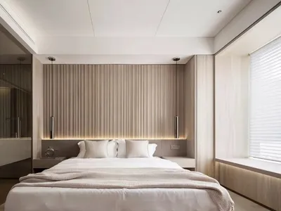 A serene modern bedroom featuring a bed with neutral-toned bedding and a wood-paneled headboard, viewed from a slightly eleva