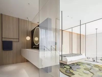 Modern minimalist bedroom featuring a wooden-paneled wall, white furniture, and a circular mirror with wooden frame.
