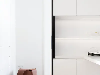 Modern minimalist residential kitchen with sleek white cabinets and clean lines.