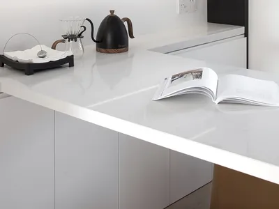 Modern minimalist kitchen with sleek white marble countertops and cabinets, featuring a minimalist pendant light fixture.