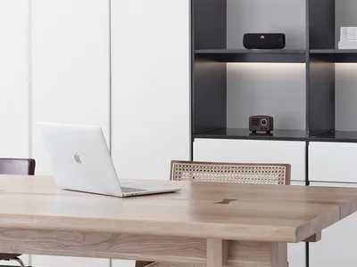 A modern home office with a wooden desk, minimalist design, and metal accents.