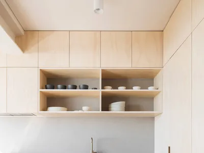 現代簡約廚房，搭配木質櫥櫃與開放式層架，展示餐具。