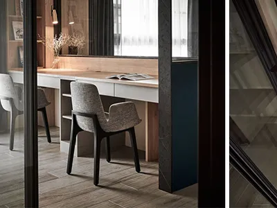 A minimalistic home office with a sleek desk, black metal shelving, and wooden elements, featuring exposed concrete walls and