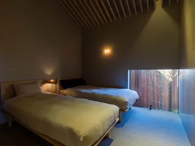 A minimalist bedroom with wooden furniture and light-colored bedding.