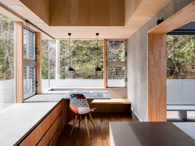 Modern minimalist kitchen with concrete countertops and wooden flooring.