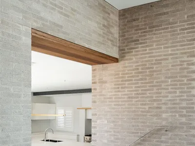 Modern kitchen with wood floor and white countertops.