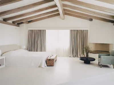 A minimalist bedroom with wood elements, soft lighting, and large windows.