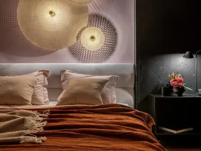 A cozy modern bedroom with a bed, pillows, and a blanket.