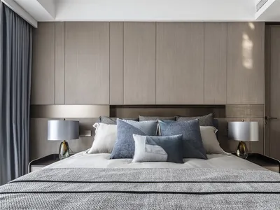 Modern minimalist bedroom with fabric bedding and wooden furniture.