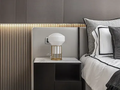 Modern minimalist bedroom featuring a marble top nightstand, wooden floor, and metal accents