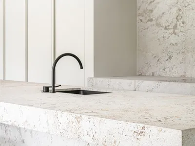 Modern minimalist kitchen featuring white marble countertops and backsplash.