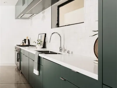現代深綠色廚櫃搭配白色檯面與白色瓷磚 backsplash。