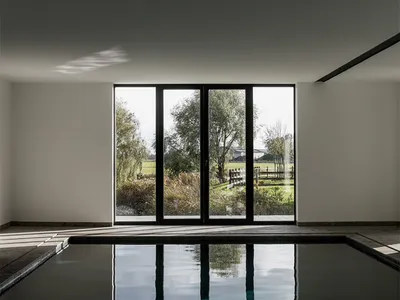 Modern glass poolside with natural landscape view