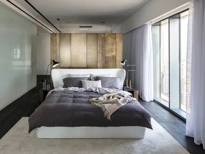 Modern bedroom with a white bed, brown metal headboard, and natural fiber bedding.