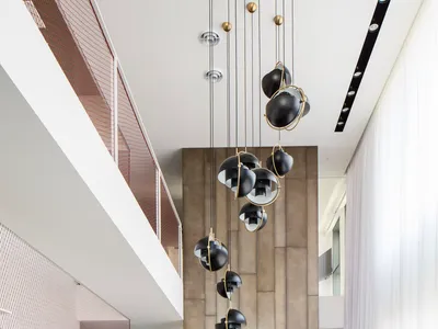 Modern restaurant interior with metal and wooden dining area, concrete backdrop, and hanging lamps.