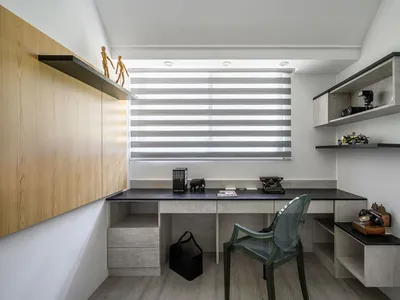 Minimalist home office featuring concrete and glass materials with a desk, chair, and shelves.