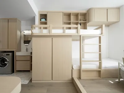 A modern minimalist bedroom with wood furnishings and storage.