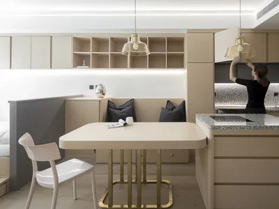Modern minimalist kitchen featuring wooden cabinets, marble countertop, and metal accents.