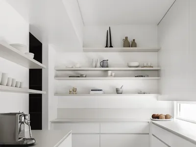 A modern, minimalist kitchen with white cabinets, stainless steel appliances, and white countertops.