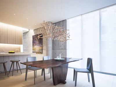 Modern kitchen featuring wooden dining table and chairs, minimalist decor, and concrete walls