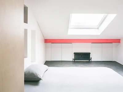 Minimalist bedroom featuring white furniture, concrete floors, and a skylight.