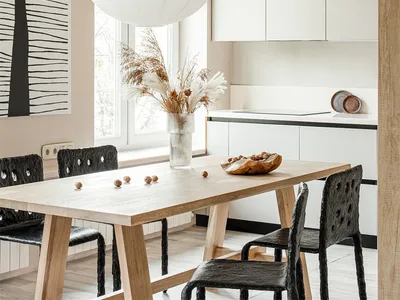 Minimalist kitchen featuring wooden table, glass vase of dry flowers, and concrete cabinets
