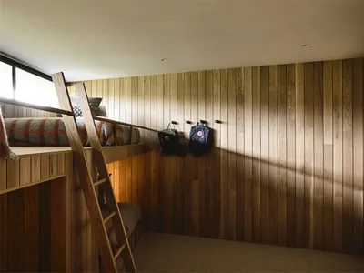 簡約臥室內設有木製雙層床與木質牆板。