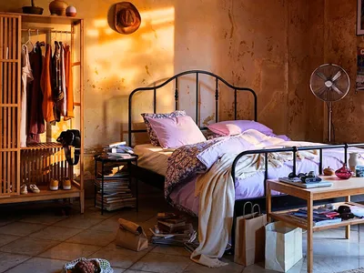 A cozy bedroom with a black iron bed, cotton textiles, and bohemian decor.